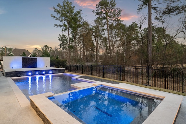 view of swimming pool featuring a fenced backyard and a pool with connected hot tub