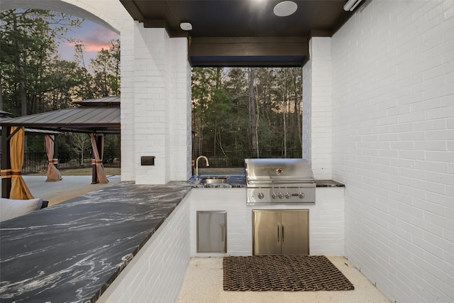 view of patio / terrace with a grill, fence, exterior kitchen, a gazebo, and a sink