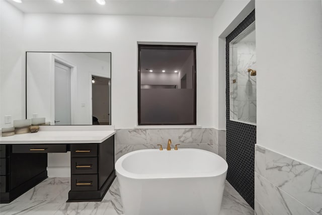 full bathroom featuring marble finish floor, a freestanding bath, a wainscoted wall, and vanity