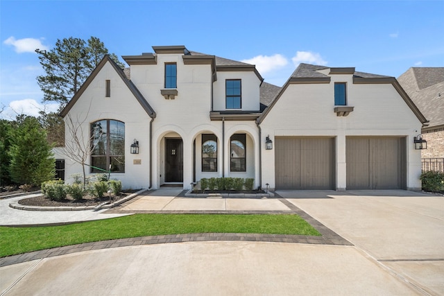 view of front of home featuring an attached garage, concrete driveway, and brick siding