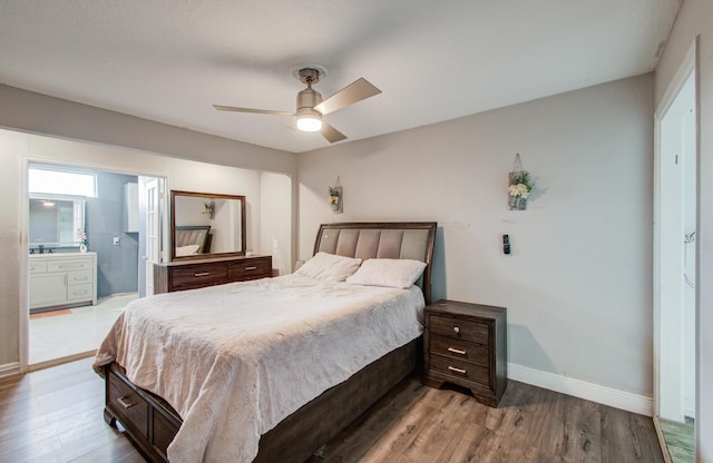 bedroom with hardwood / wood-style flooring, ceiling fan, and ensuite bath