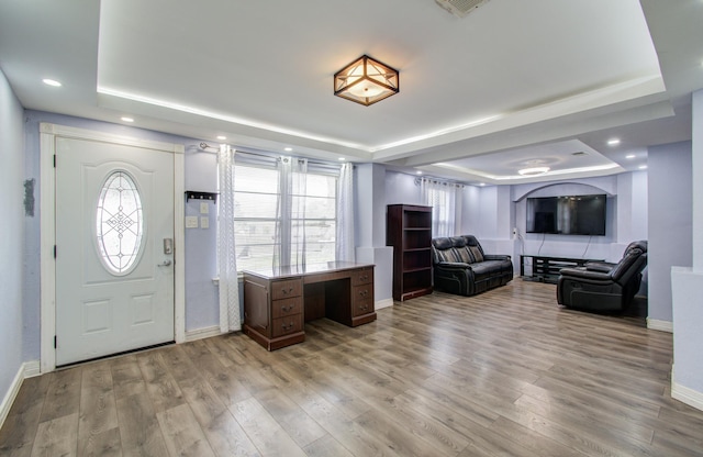 entrance foyer featuring light hardwood / wood-style flooring and a tray ceiling