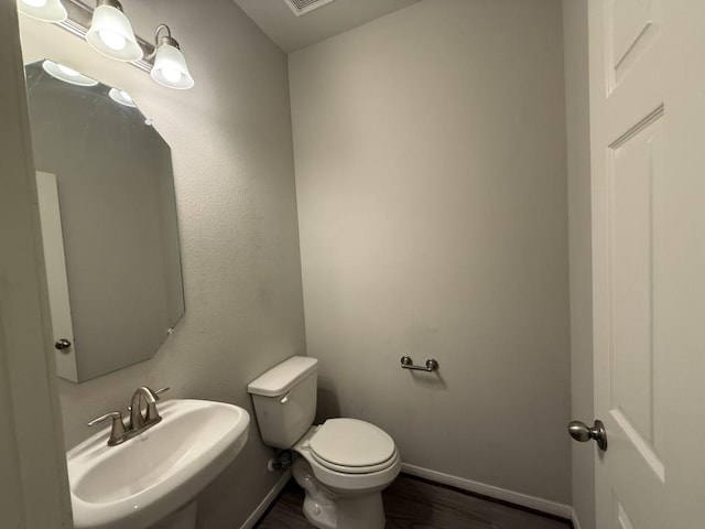 bathroom featuring hardwood / wood-style flooring, toilet, and sink