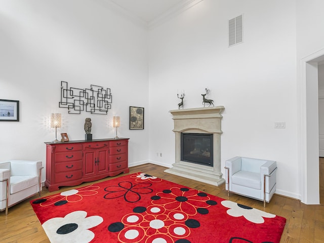 living area featuring crown molding and wood-type flooring