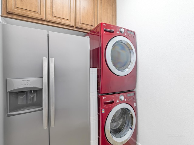 washroom with stacked washer and dryer and cabinets