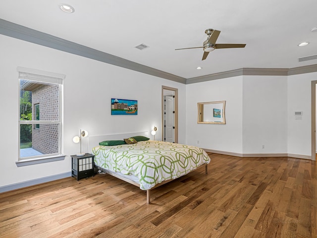 bedroom with ceiling fan, ornamental molding, and wood-type flooring