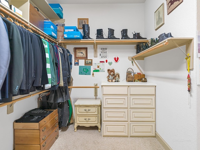 walk in closet featuring light colored carpet