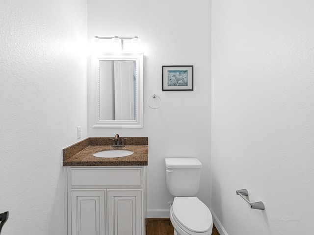 bathroom featuring vanity, toilet, and hardwood / wood-style floors