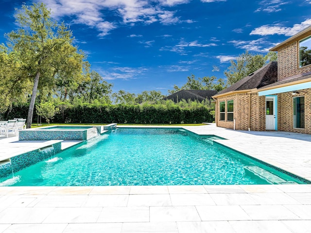 view of swimming pool featuring an in ground hot tub, pool water feature, and a patio area