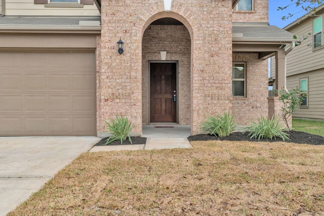 doorway to property featuring a garage and a yard