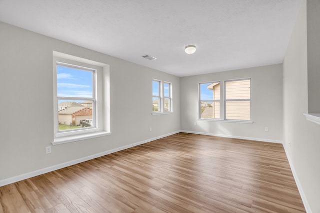 spare room with a healthy amount of sunlight and light hardwood / wood-style flooring