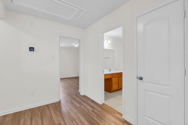 hallway featuring sink and light hardwood / wood-style floors