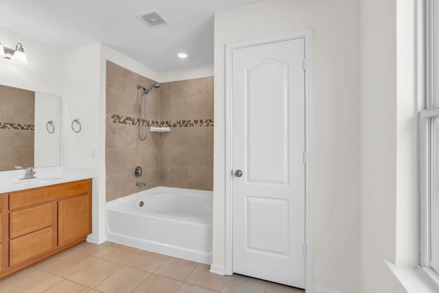 bathroom with tiled shower / bath, tile patterned floors, and vanity