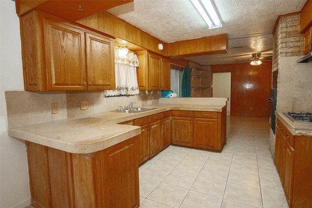 kitchen featuring sink, a textured ceiling, kitchen peninsula, ceiling fan, and decorative backsplash