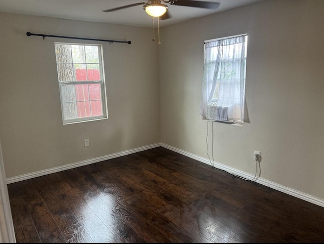 empty room featuring ceiling fan, a wealth of natural light, and dark hardwood / wood-style flooring