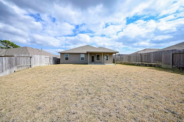 rear view of house featuring a lawn