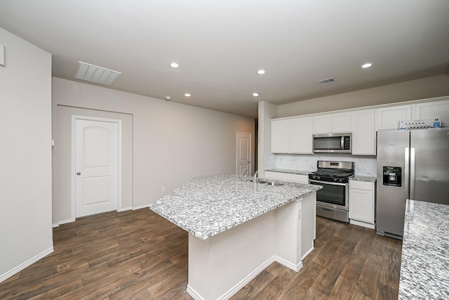 kitchen featuring sink, stainless steel appliances, light stone counters, white cabinets, and a center island with sink