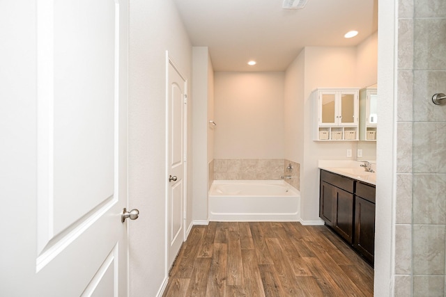 bathroom with vanity, wood-type flooring, and a bathing tub