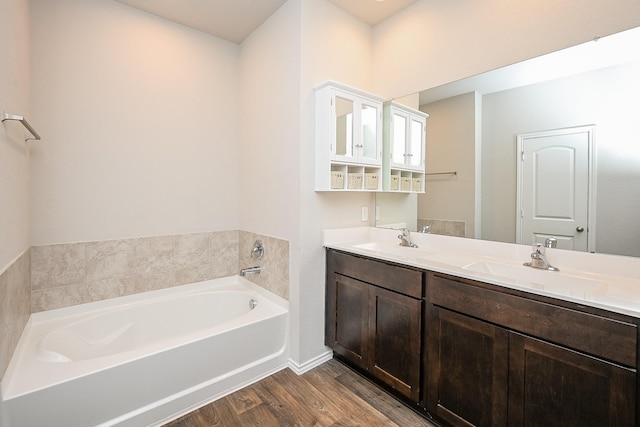 bathroom featuring hardwood / wood-style flooring, vanity, and a tub