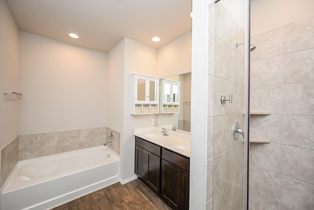 bathroom with hardwood / wood-style flooring, vanity, and shower with separate bathtub