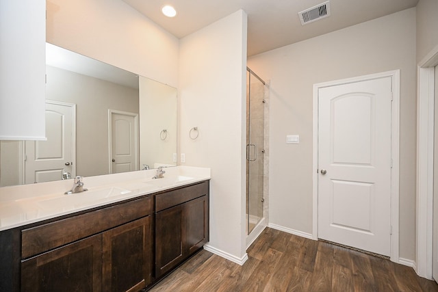 bathroom with wood-type flooring, vanity, and walk in shower