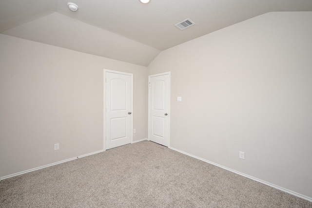 unfurnished room featuring lofted ceiling and carpet