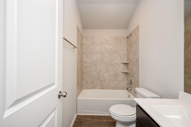 full bathroom featuring vanity, tiled shower / bath combo, and toilet