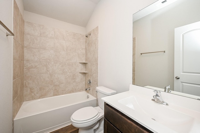 full bathroom featuring vanity, toilet, tiled shower / bath combo, and vaulted ceiling