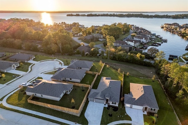 aerial view at dusk featuring a water view