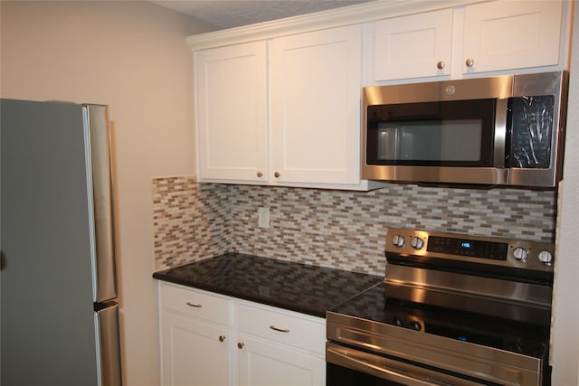 kitchen with stainless steel appliances, white cabinets, and decorative backsplash