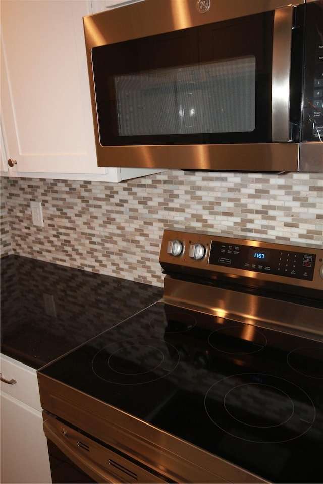 interior details featuring white cabinetry, appliances with stainless steel finishes, and tasteful backsplash