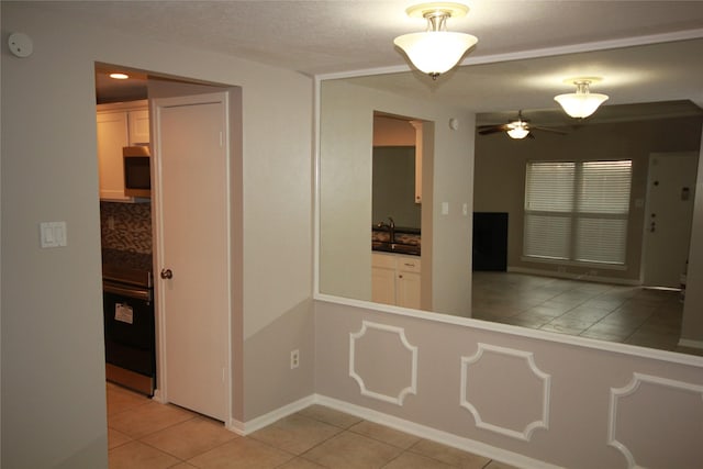 hall featuring sink and light tile patterned floors