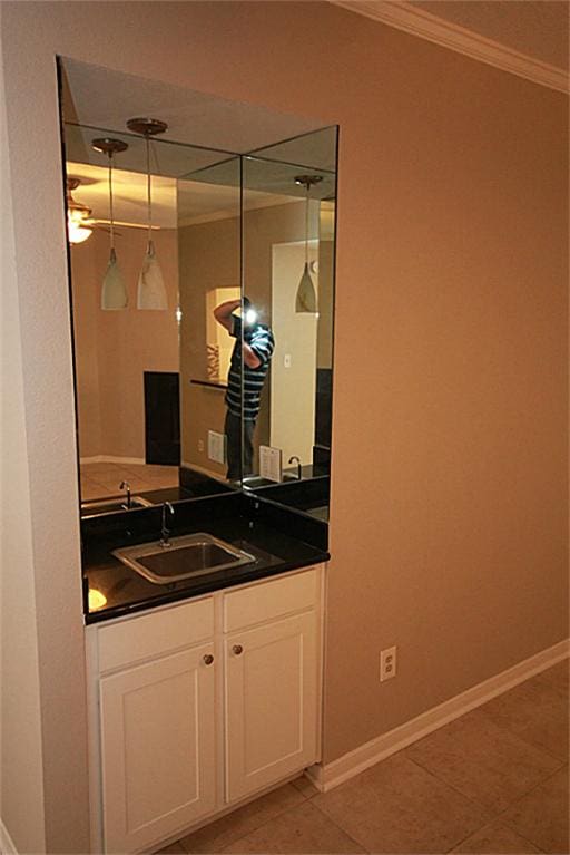 bathroom featuring crown molding, vanity, and tile patterned flooring