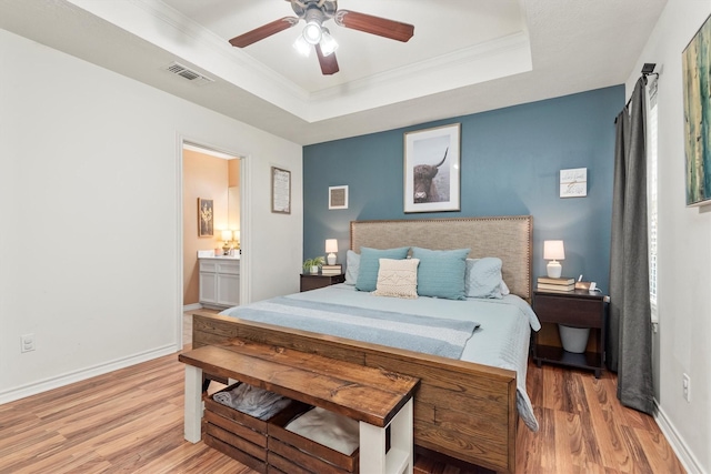 bedroom with crown molding, ceiling fan, wood-type flooring, and a raised ceiling