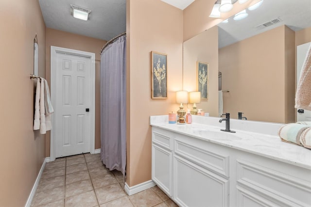 bathroom featuring tile patterned floors, curtained shower, vanity, and a textured ceiling