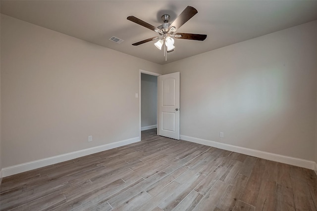 empty room with ceiling fan and light hardwood / wood-style flooring