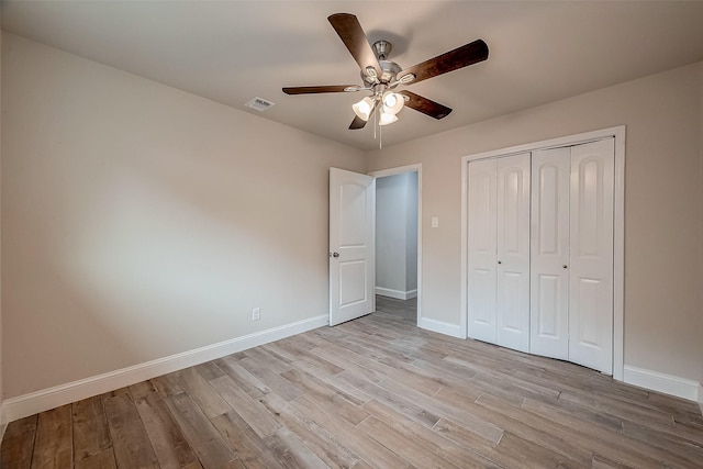 unfurnished bedroom featuring ceiling fan, a closet, and light wood-type flooring