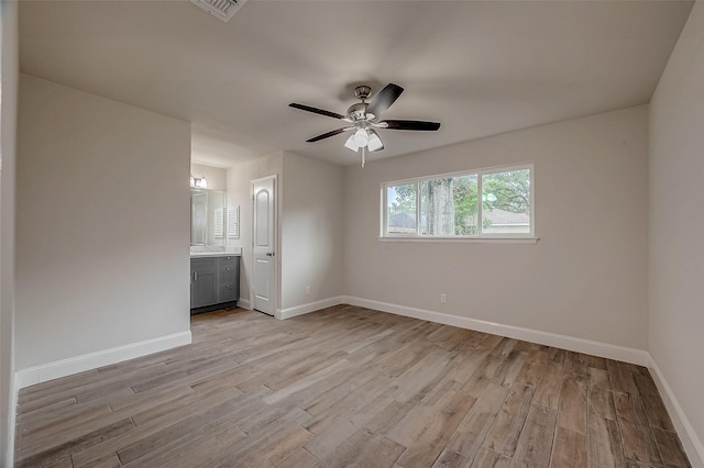 unfurnished bedroom with ceiling fan, ensuite bathroom, and light hardwood / wood-style flooring