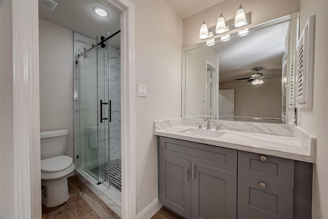 bathroom with hardwood / wood-style flooring, vanity, ceiling fan, toilet, and a shower with door