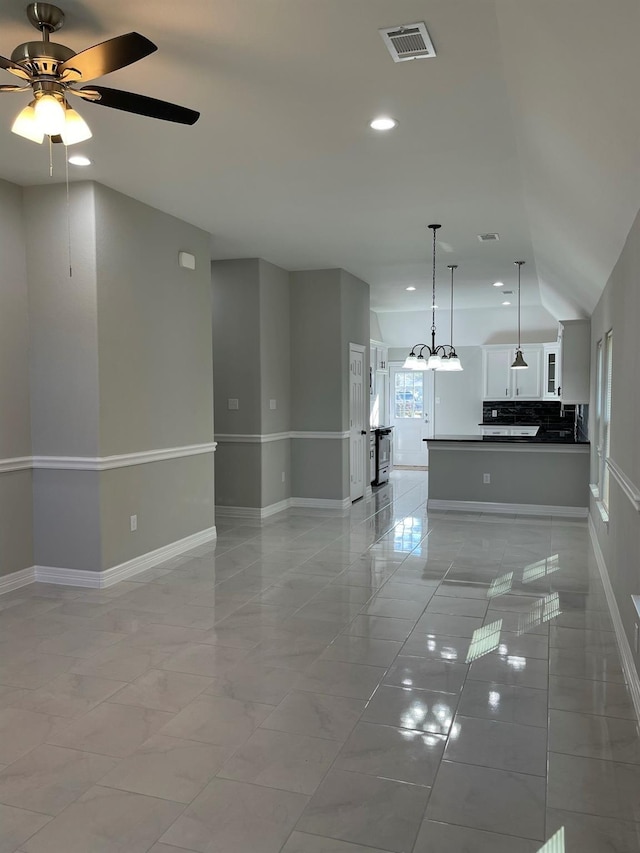 interior space with vaulted ceiling and ceiling fan with notable chandelier