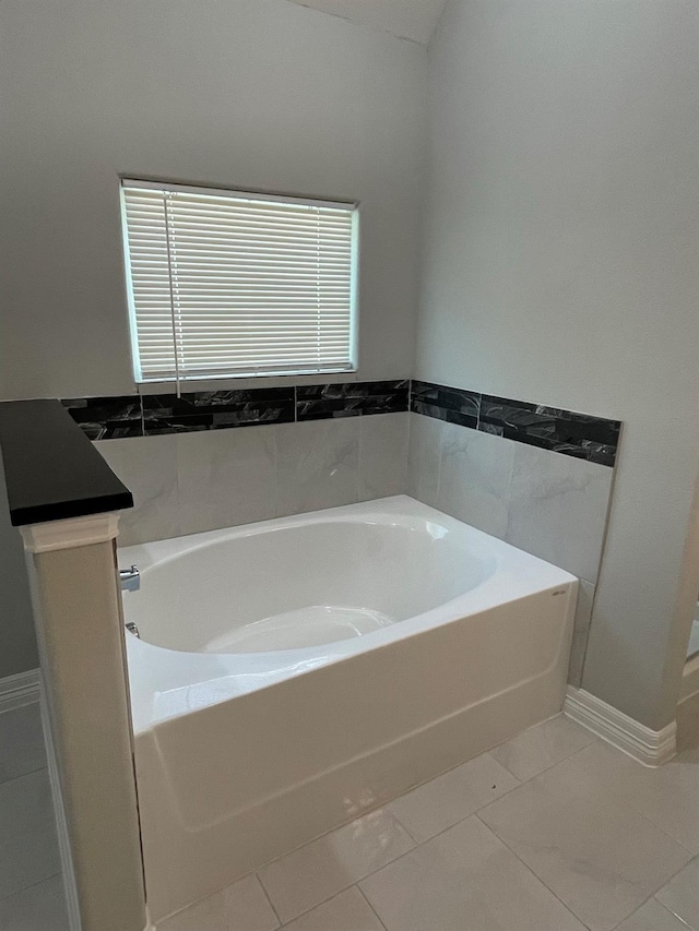 bathroom featuring tile patterned floors and a tub to relax in