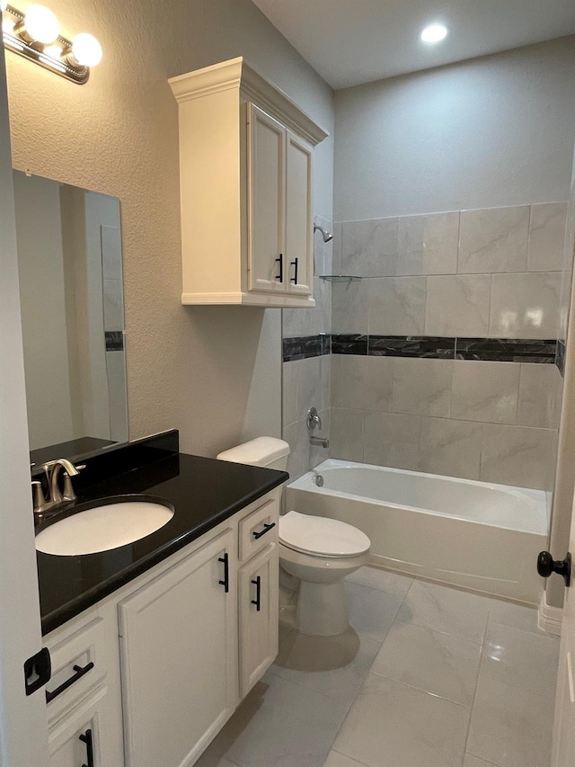 full bathroom with tiled shower / bath, vanity, and toilet