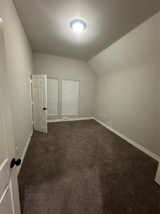 bonus room with vaulted ceiling, a textured ceiling, and dark colored carpet