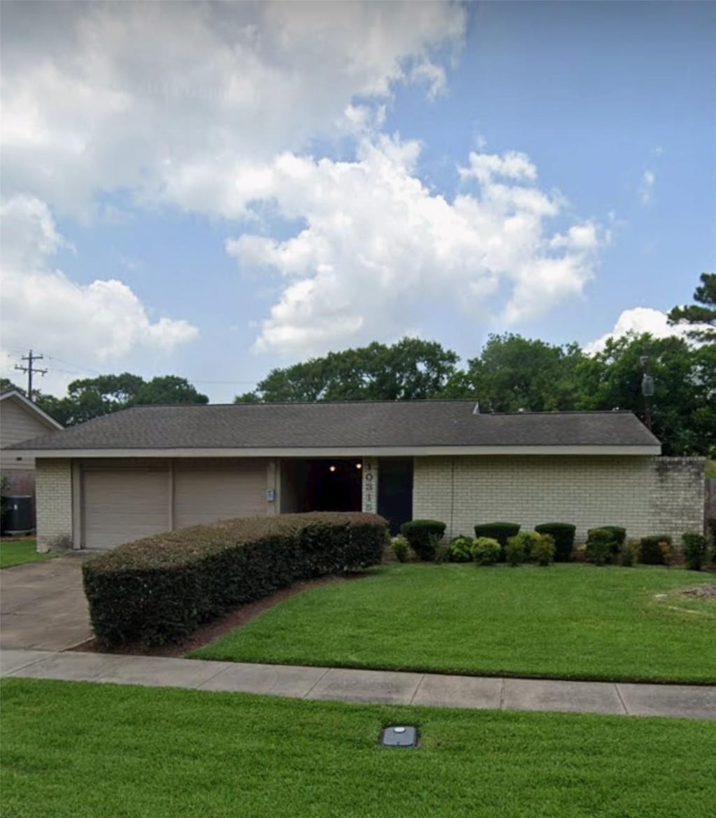 ranch-style house with a garage and a front yard