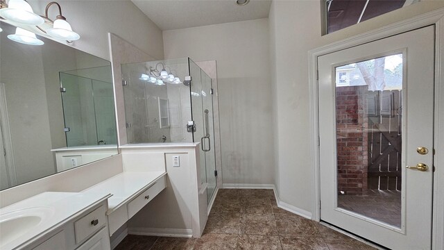 bathroom with a stall shower, baseboards, and vanity