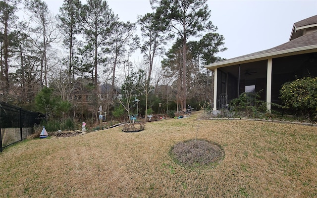 view of yard featuring fence and a sunroom