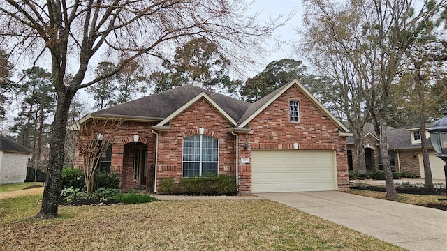 traditional-style home featuring a garage, brick siding, concrete driveway, roof with shingles, and a front yard