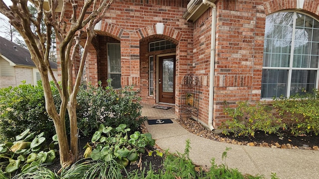 doorway to property featuring brick siding