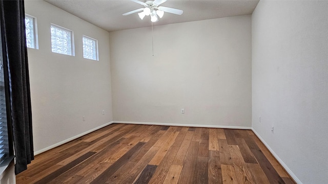 empty room featuring dark wood-type flooring, ceiling fan, and baseboards