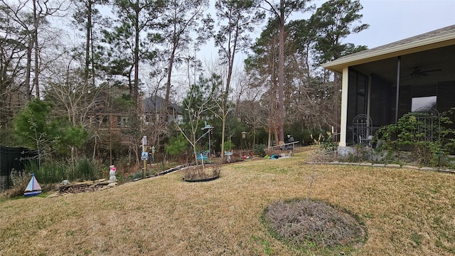 view of yard with a ceiling fan and a sunroom